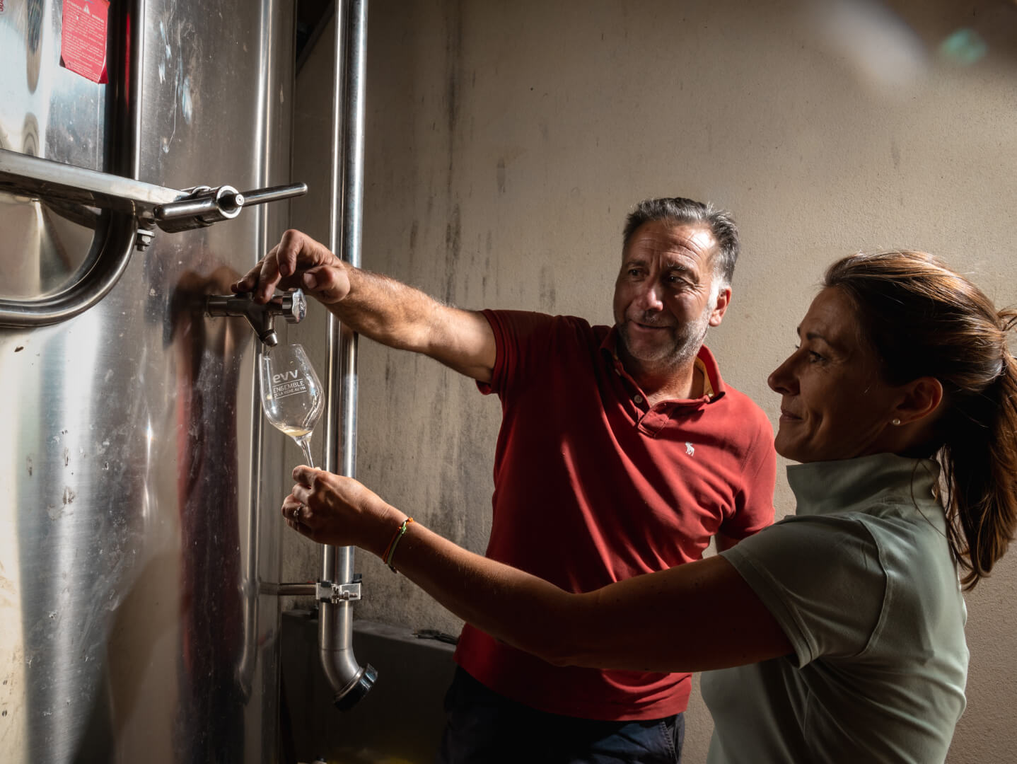 a man and a woman about to taste wine
